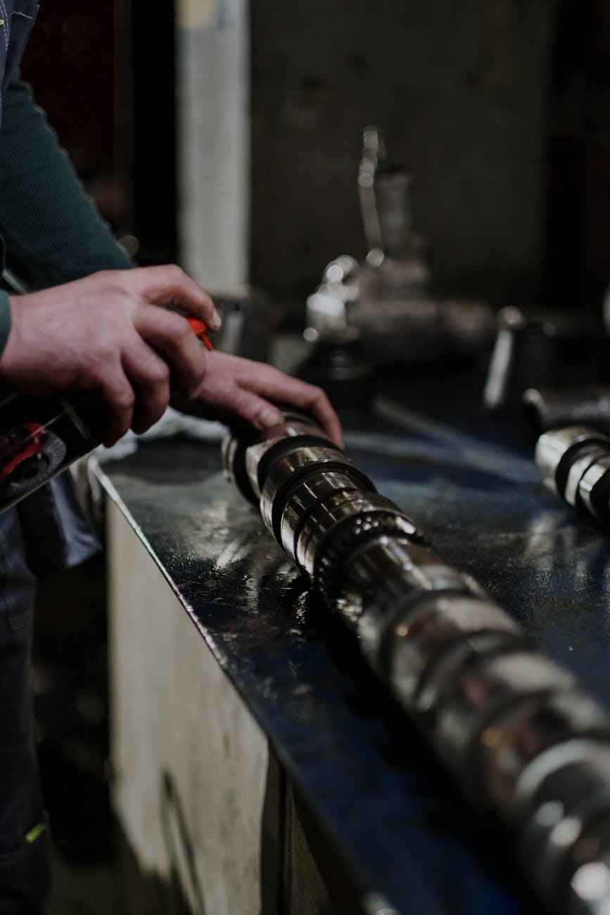 Mains travaillant sur une pièce métallique en atelier