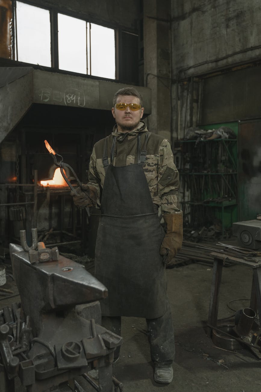 Forgeron au travail dans une forge avec équipements et flammes