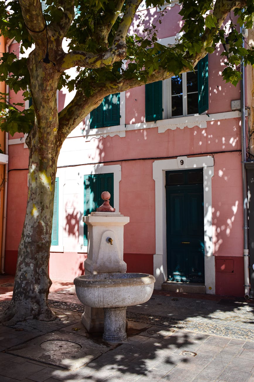 Fontaine en pierre devant une maison provençale colorée