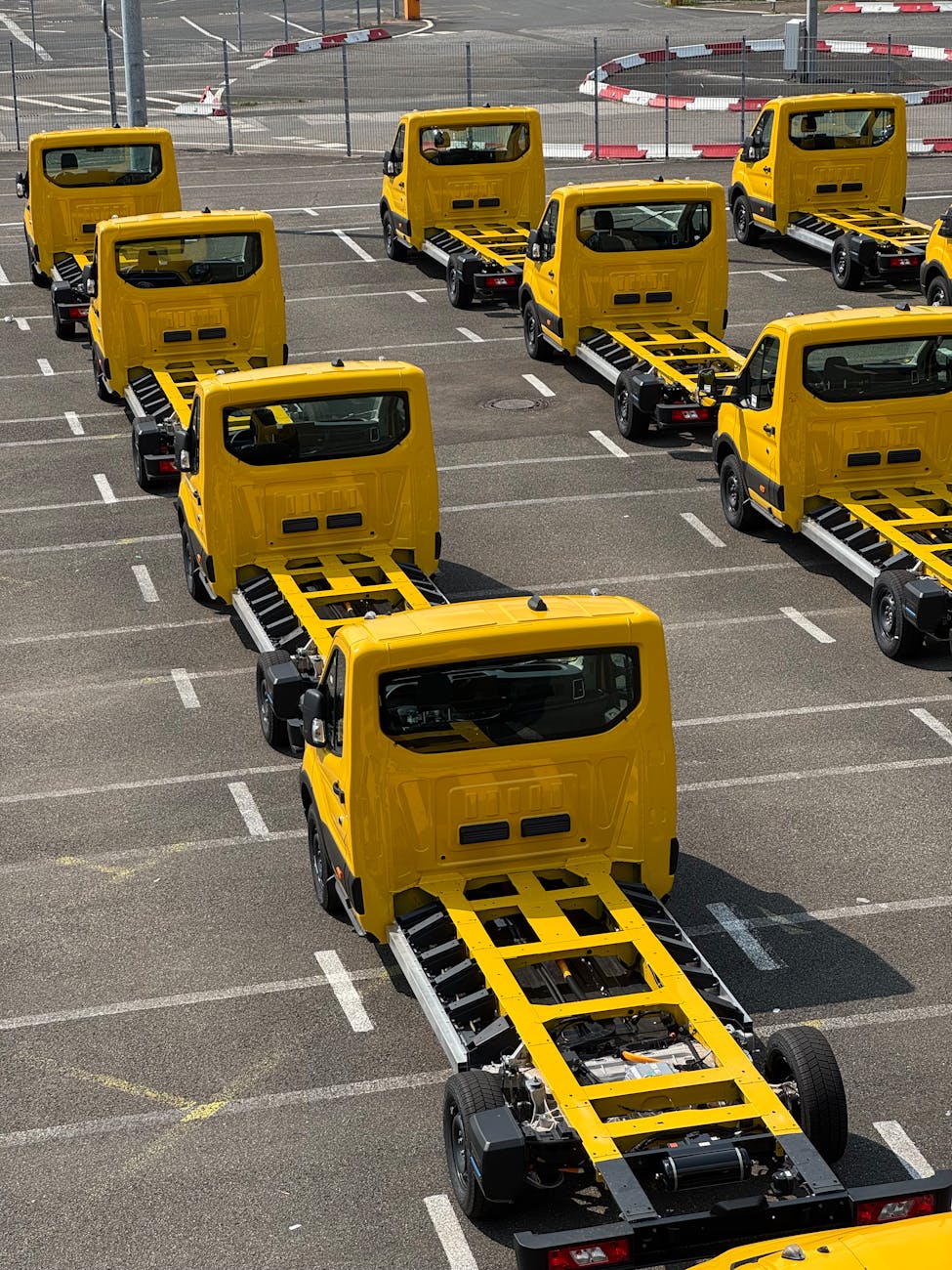 Châssis de camions jaunes alignés en zone industrielle