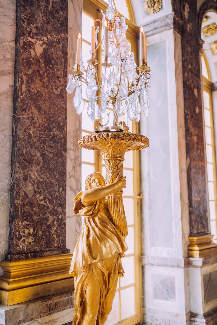 Sculpture dorée portant un chandelier dans le Château de Versailles