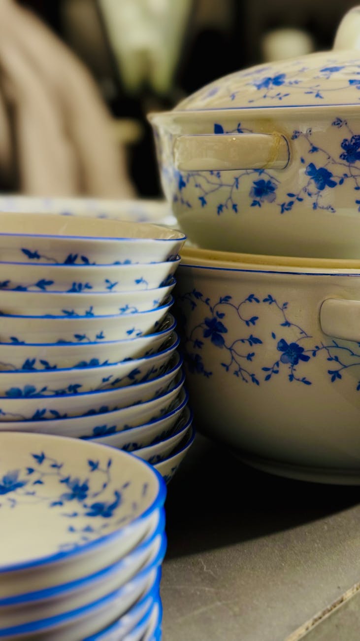 Vaisselle en porcelaine empilée avec motifs floraux bleus, savoir-faire artisanal