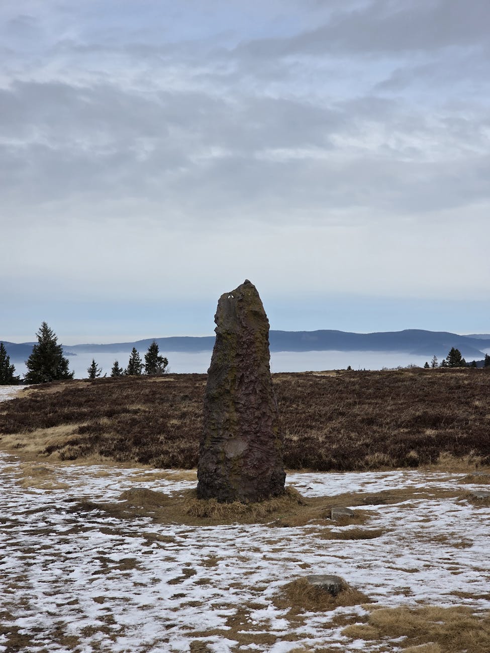 Menhir solitaire dans un paysage hivernal vosgien