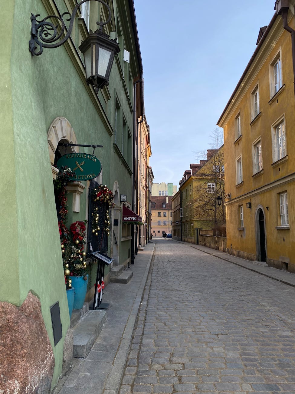 Brukowana uliczka Starego Miasta w Warszawie z kolorowymi kamienicami