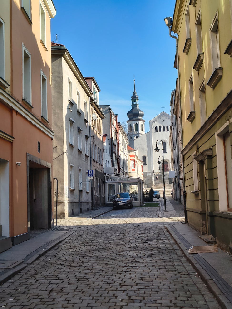 Brukowana uliczka z zabytkowym kościołem w Opolu