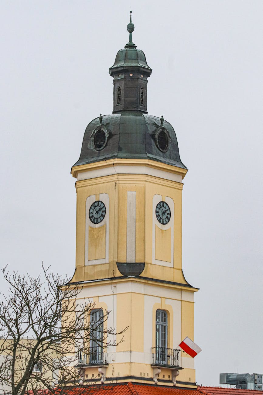 Wieża zegarowa ratusza z flagą Polski w Białymstoku